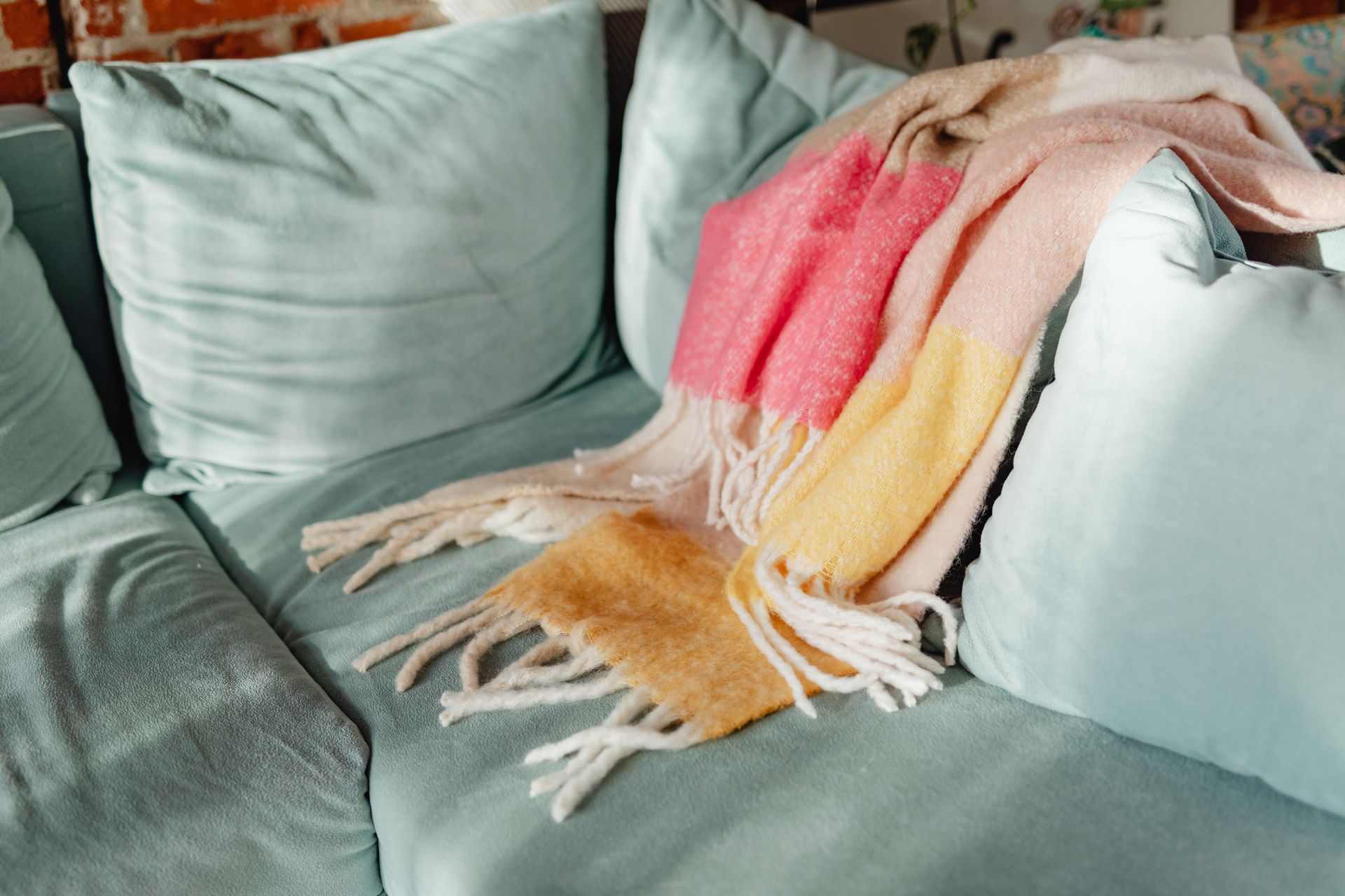 A warm throw blanket draped over a sofa in a cozy living room