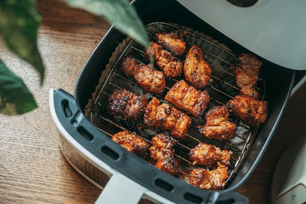 Crispy chicken cooking inside a modern basket air fryer