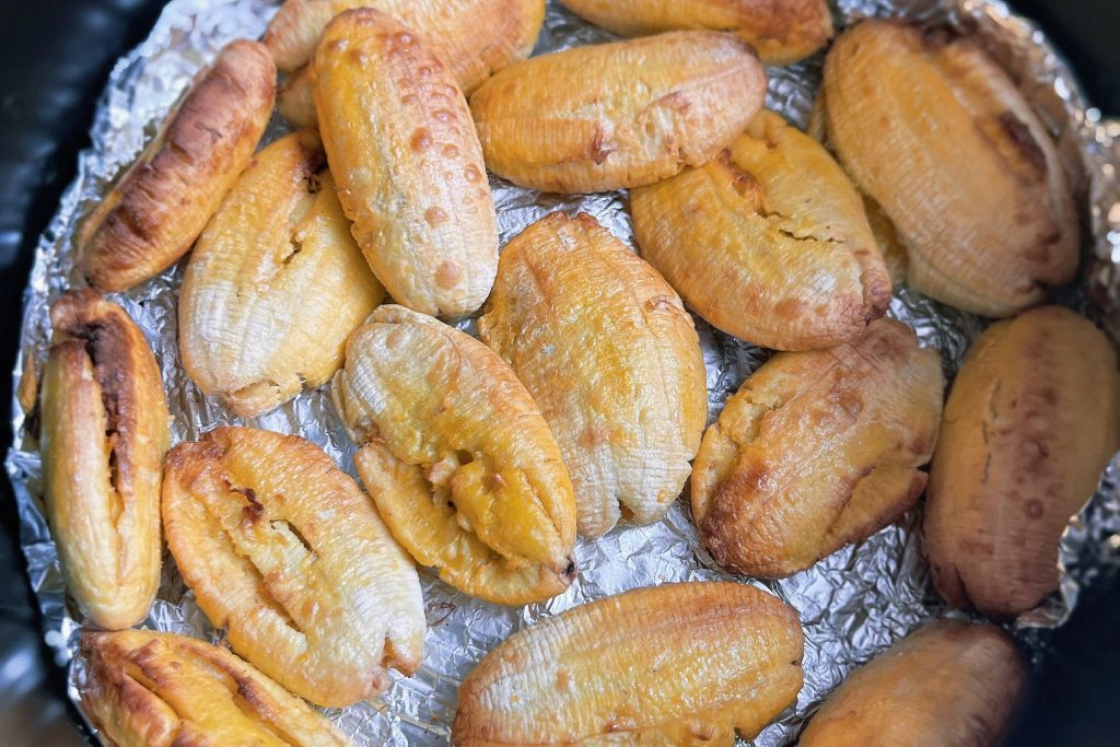 Golden baked plantains on foil inside an air fryer basket