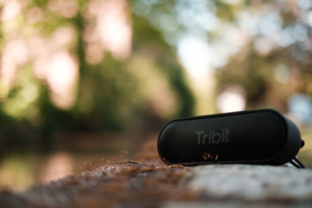 Portable speaker outdoors on a bench in a green park