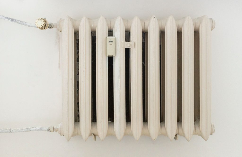 White ribbed radiator heater on a wall in a bright room