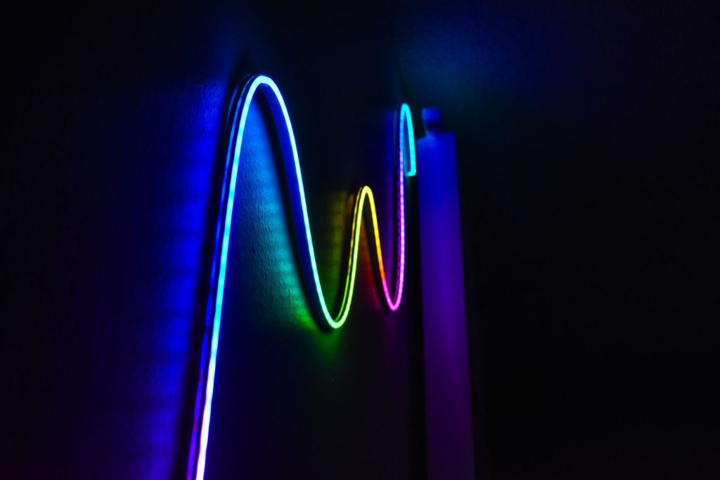 Colorful LED strip light glowing in a wave pattern on a dark wall