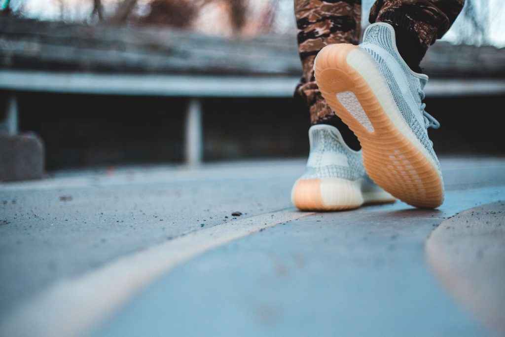Cushioned sneakers mid-stride on a city street
