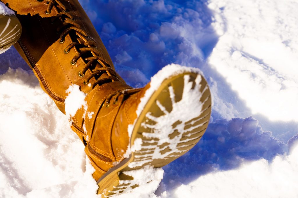 Brown boots in deep snow, close-up